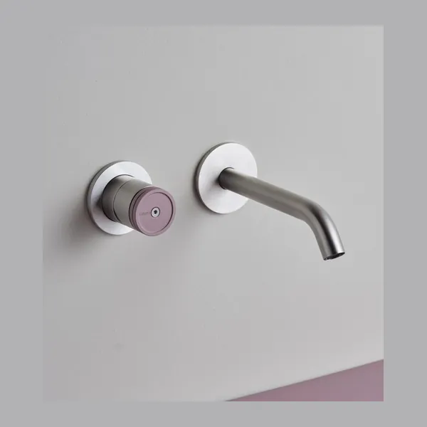 Wall mounted basin set in brushed stainless steel with a straight spout and a separate control on the tiled wall