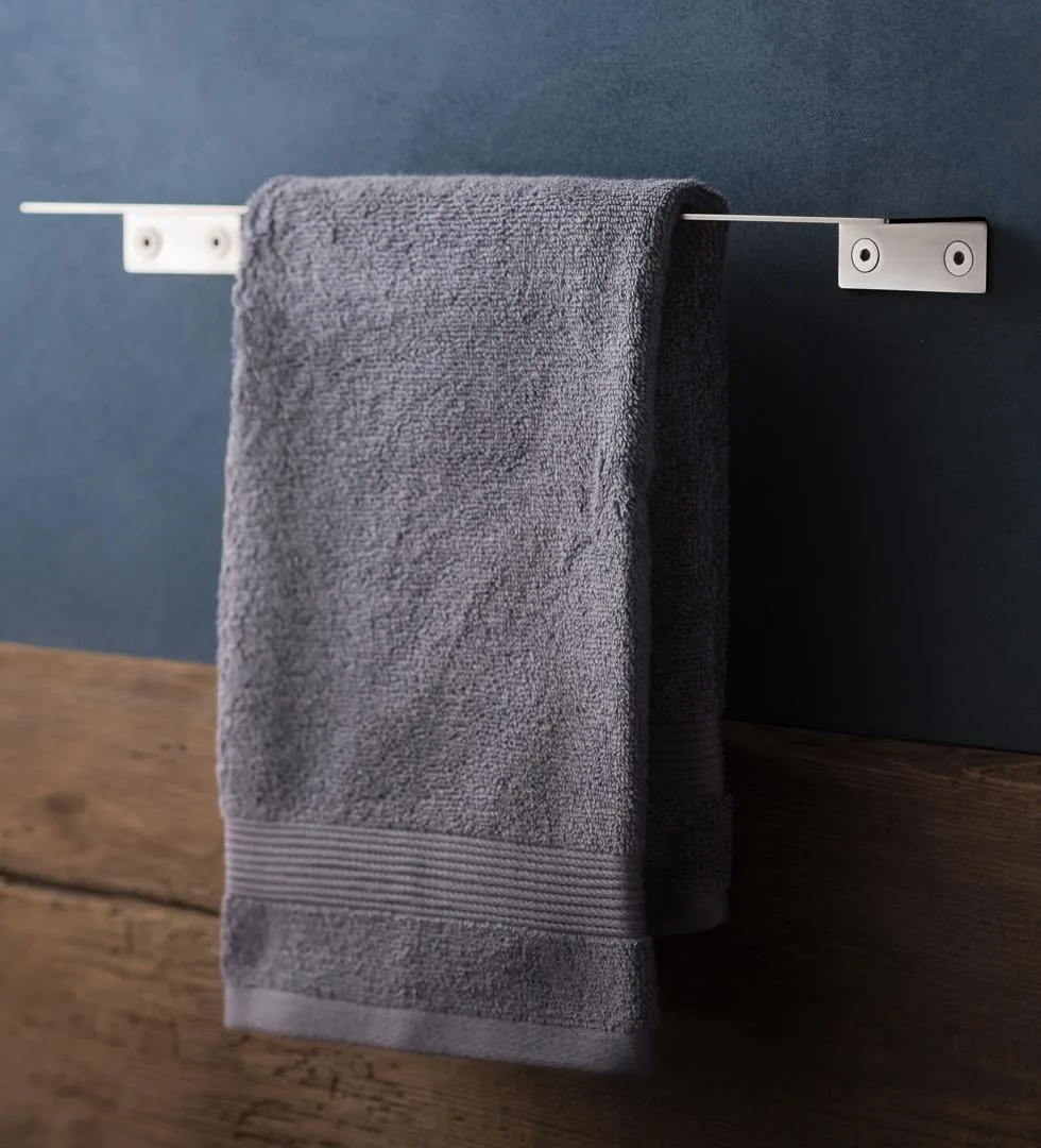 Brushed stainless steel towel rail with a towel draped over it